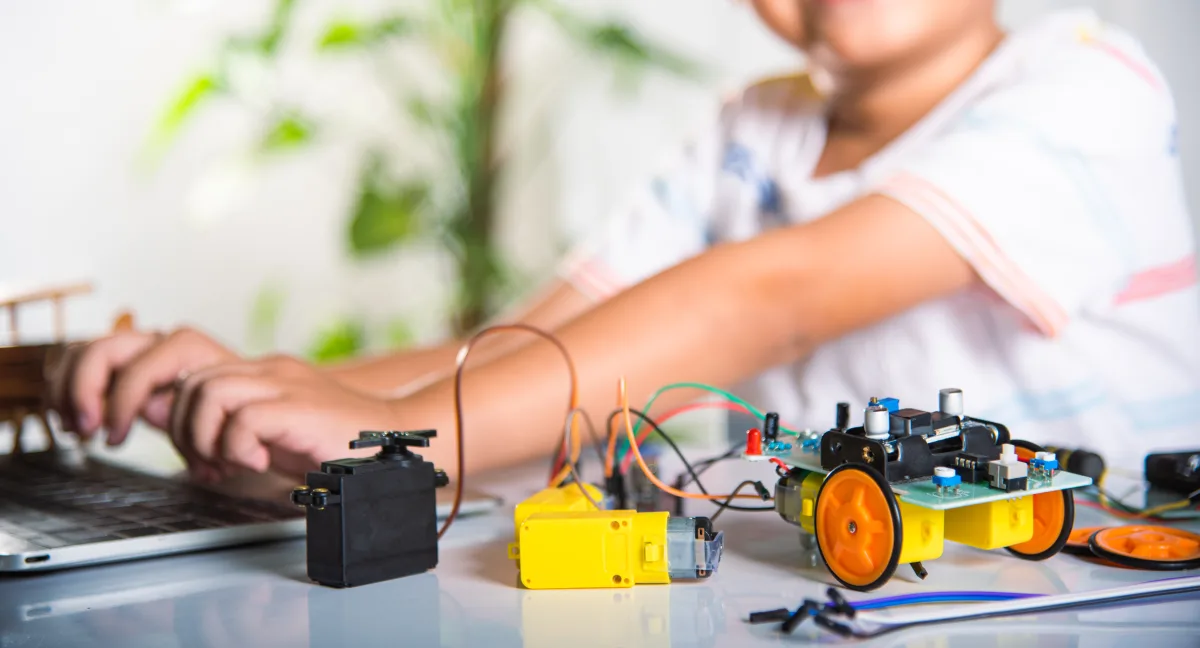 Asian kid boy learns coding and programming with laptop for Ardu