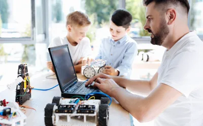 Young robotics teacher working on the laptop