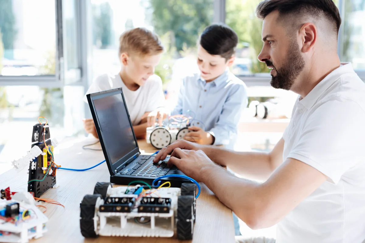 Young robotics teacher working on the laptop