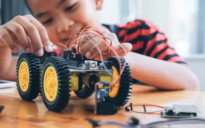 Concentrated boy creating robot at lab.