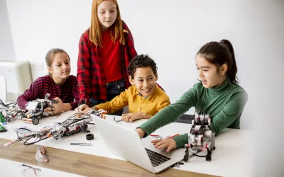 Happy kids programming electric toys and robots at robotics clas